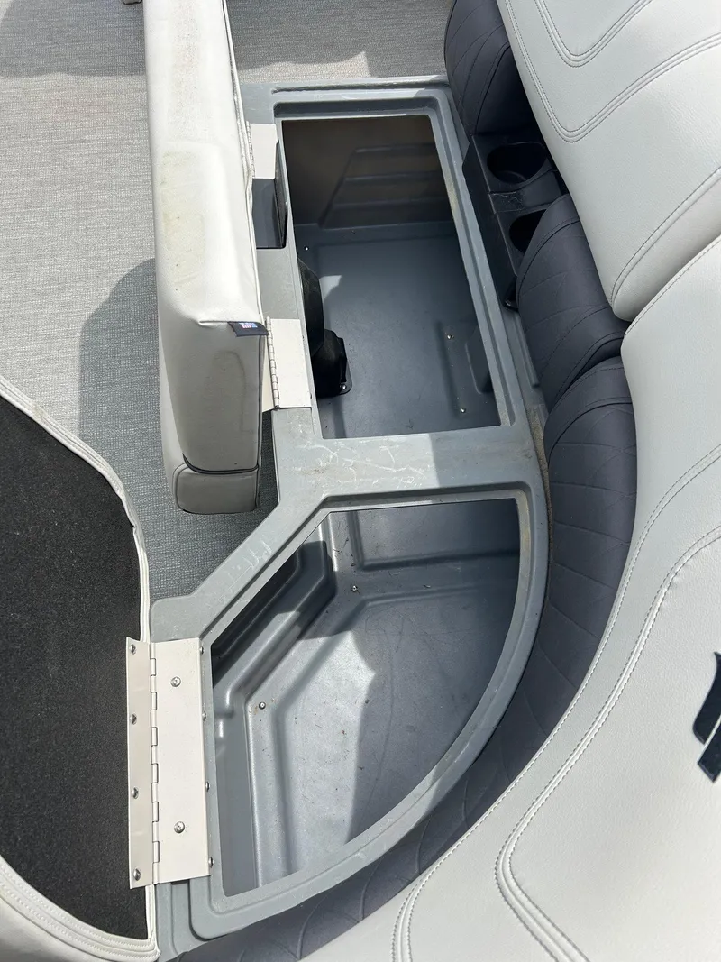 Slide: The Image of 2022 Starcraft CX21 boat storage compartment with open seat and gray interior. - 23