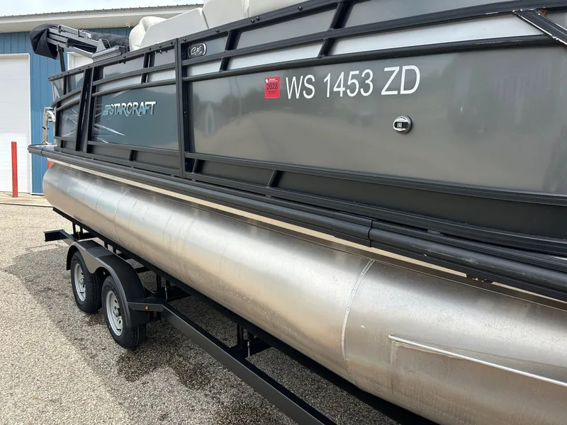 Slide: The Image of 2022 Starcraft CX21 pontoon boat on trailer, close-up of aluminum hull and black railing. - 4