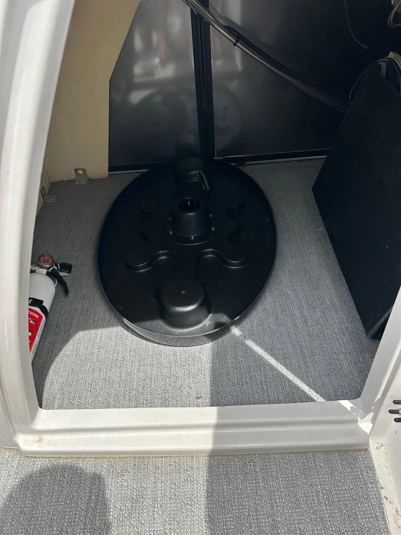 Slide: The Image of Storage compartment of 2022 Starcraft CX21 with fire extinguisher and black cover. - 44