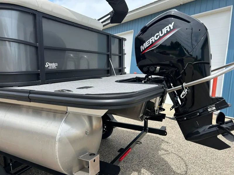 Slide: The Image of 2022 Starcraft CX21 boat with Mercury outboard motor, parked near a blue building. - 49