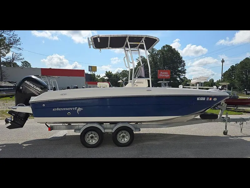 Slide: The Image of 2019 Bayliner Element F21 boat on trailer, blue hull, Mercury outboard motor, sunny day. - 19