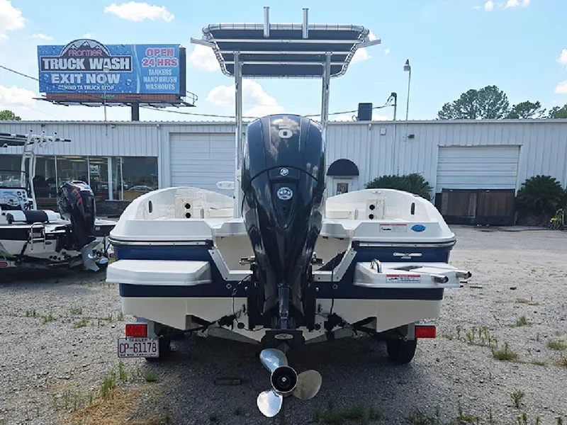 Slide: The Image of 2019 Bayliner Element F21 boat with outboard motor, parked near a truck wash facility. - 6