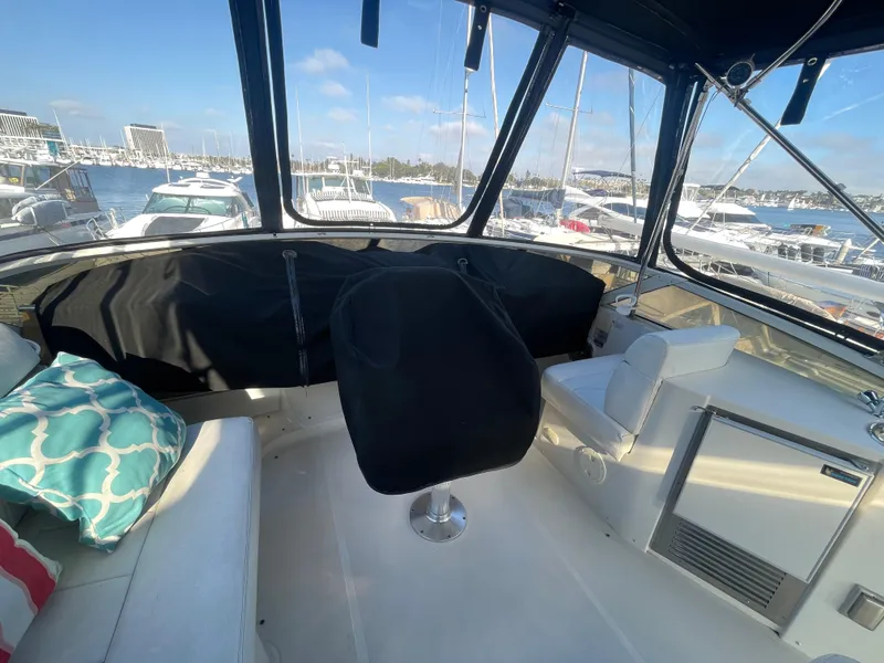 Slide: The Image of 2004 Carver 44 Cockpit Motor Yacht interior with marina view, featuring seating and helm. - 11