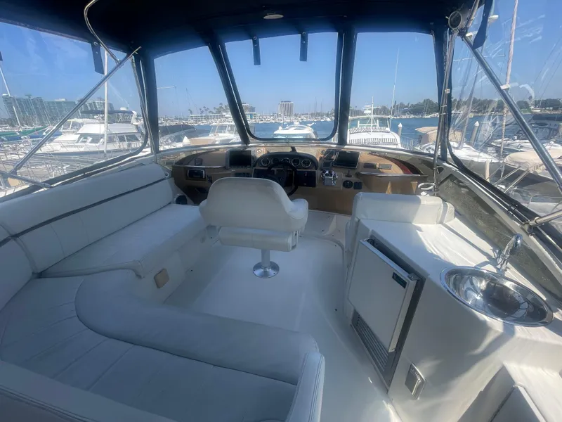 Slide: The Image of Interior of 2004 Carver 44 Cockpit Motor Yacht with helm, seating, and marina view. - 17
