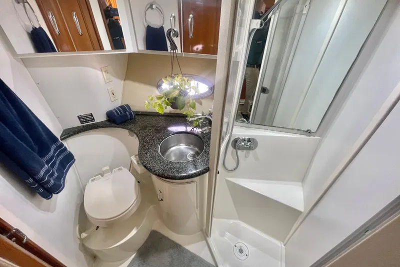 Slide: The Image of 2004 Carver 44 Cockpit Motor Yacht bathroom with shower, sink, and toilet. - 58