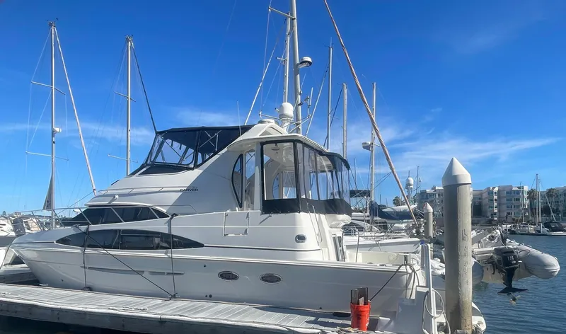 The Image of 2004 Carver 44 Cockpit Motor Yacht docked at marina under clear blue sky. - 0