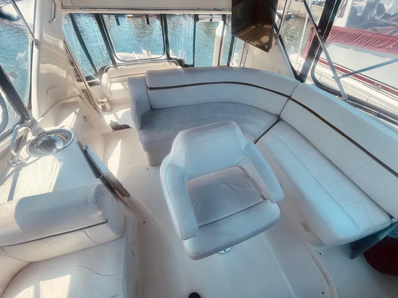 Slide: The Image of 2004 Carver 44 Cockpit Motor Yacht interior with white seating and panoramic windows. - 19
