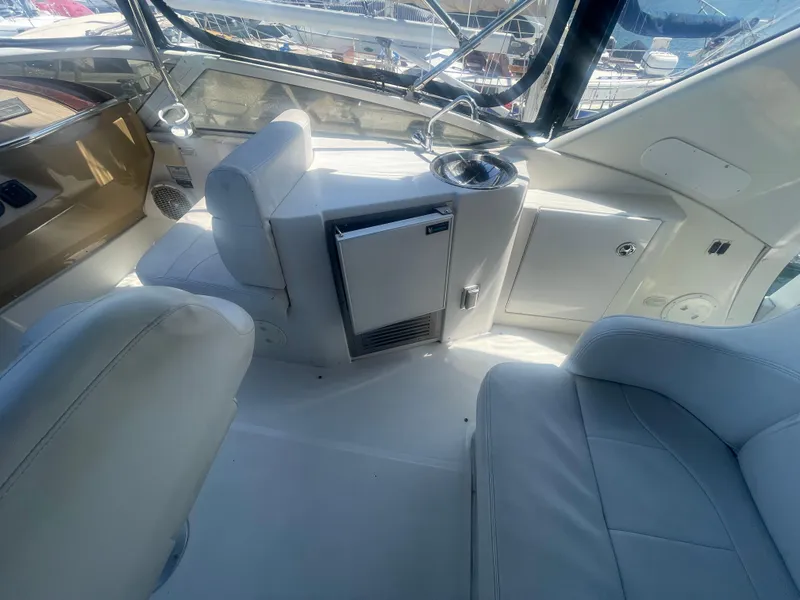 Slide: The Image of 2004 Carver 44 Cockpit Motor Yacht interior with seating, mini fridge, and sink. - 20