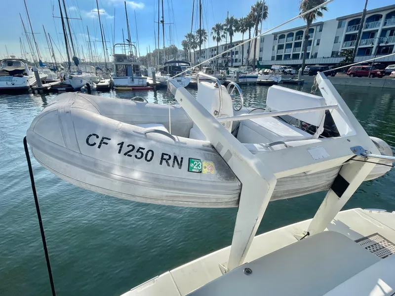 Slide: The Image of A 2004 Carver 44 Cockpit Motor Yacht with a small dinghy in a marina setting. - 6