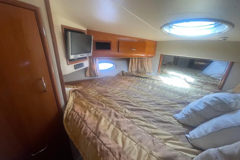Slide: The Image of Cozy bedroom in 2004 Carver 44 Cockpit Motor Yacht with TV and porthole window. - 60
