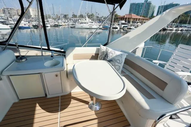 Slide: The Image of 2006 Carver 42 Super Sport yacht interior with seating, table, and marina view. - 22