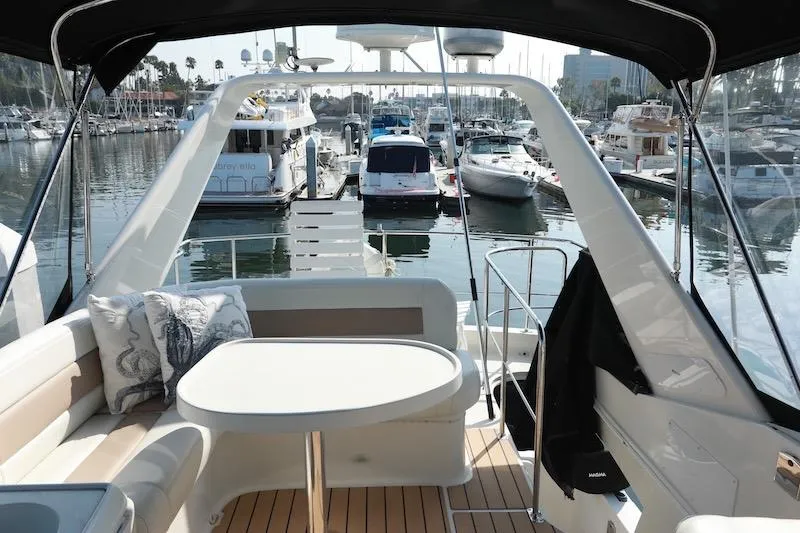 Slide: The Image of 2006 Carver 42 Super Sport yacht interior with marina view, featuring seating and table. - 23