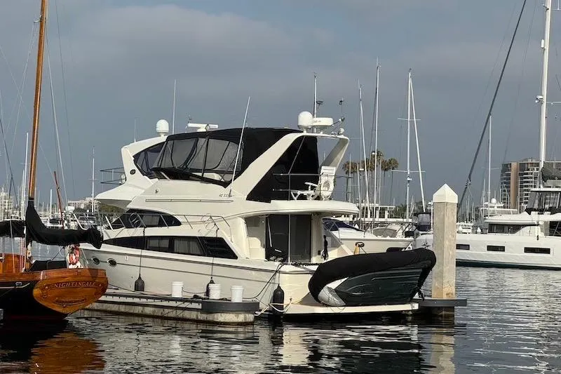 Slide: The Image of 2006 Carver 42 Super Sport yacht docked in a marina, surrounded by sailboats. - 3