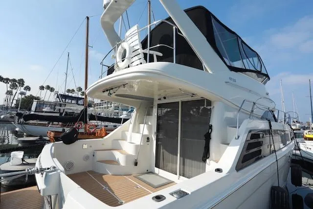 Slide: The Image of 2006 Carver 42 Super Sport yacht docked at marina, featuring spacious deck and modern design. - 5
