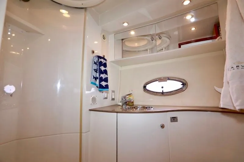 Slide: The Image of 2006 Carver 42 Super Sport yacht bathroom with sink, mirror, and porthole window. - 53