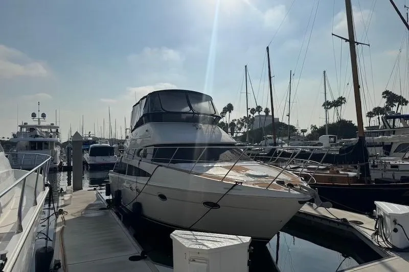 Slide: The Image of 2006 Carver 42 Super Sport yacht docked at marina under sunny sky. - 64