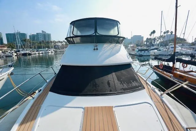 Slide: The Image of 2006 Carver 42 Super Sport yacht docked in a marina, surrounded by other boats. - 7