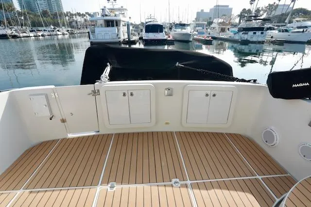 Slide: The Image of 2006 Carver 42 Super Sport yacht deck with marina view, featuring teak flooring. - 8