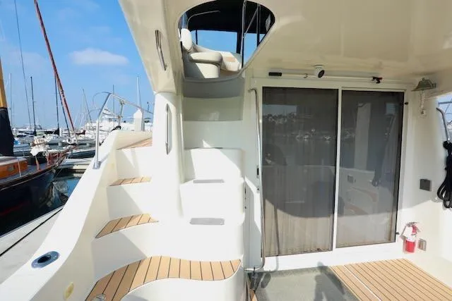 Slide: The Image of 2006 Carver 42 Super Sport yacht with elegant deck and staircase in marina setting. - 9