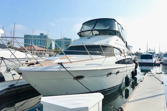 The Image of 2006 Carver 42 Super Sport yacht docked at marina under clear sky. - 0
