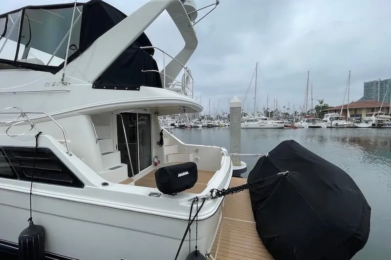 Slide: The Image of 2006 Carver 42 Super Sport yacht docked at marina, overcast sky. - 13