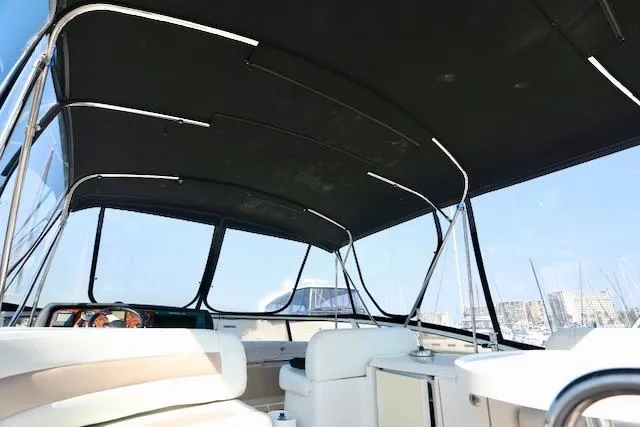 Slide: The Image of 2006 Carver 42 Super Sport yacht interior with black canopy and marina view. - 26