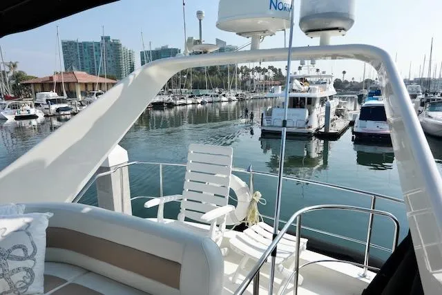 Slide: The Image of 2006 Carver 42 Super Sport yacht interior with marina view, featuring seating and navigation equipment. - 27