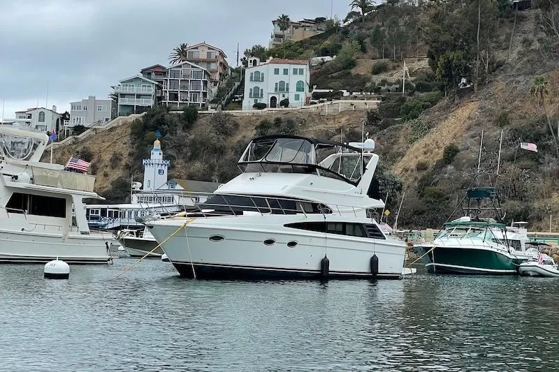 Slide: The Image of 2006 Carver 42 Super Sport yacht docked in scenic harbor with hillside homes. - 4
