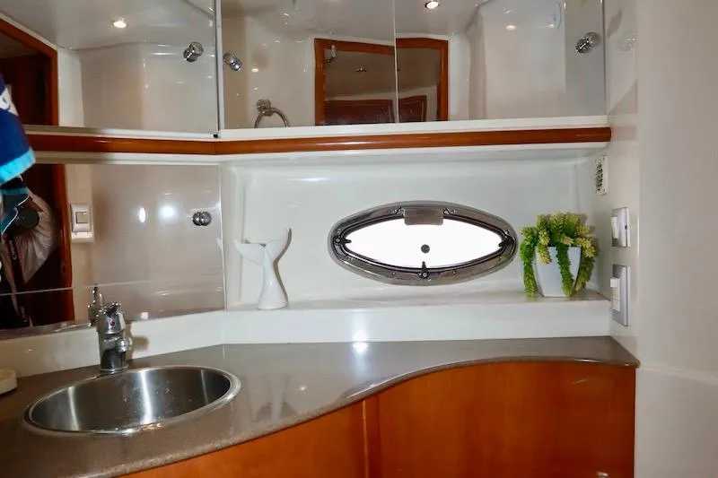 Slide: The Image of 2006 Carver 42 Super Sport yacht bathroom with sink, mirror, and porthole window. - 49