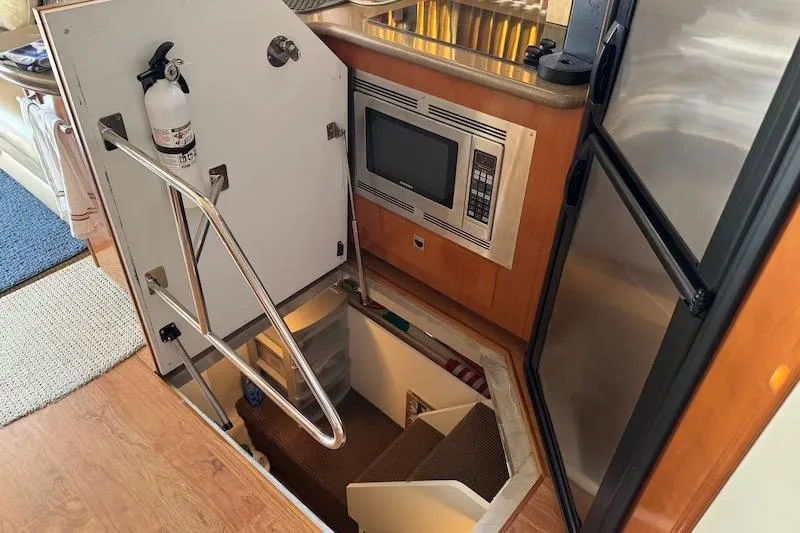 Slide: The Image of Interior of 2006 Carver 42 Super Sport yacht with kitchen and stairway access. - 55