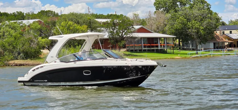 Slide: The Image of 2020 Chaparral 317 SSX boat cruising on a scenic lake near waterfront homes. - 10