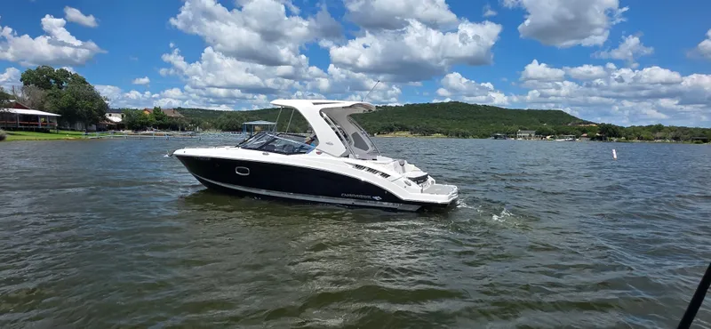 Slide: The Image of 2020 Chaparral 317 SSX boat cruising on a scenic lake under a partly cloudy sky. - 13