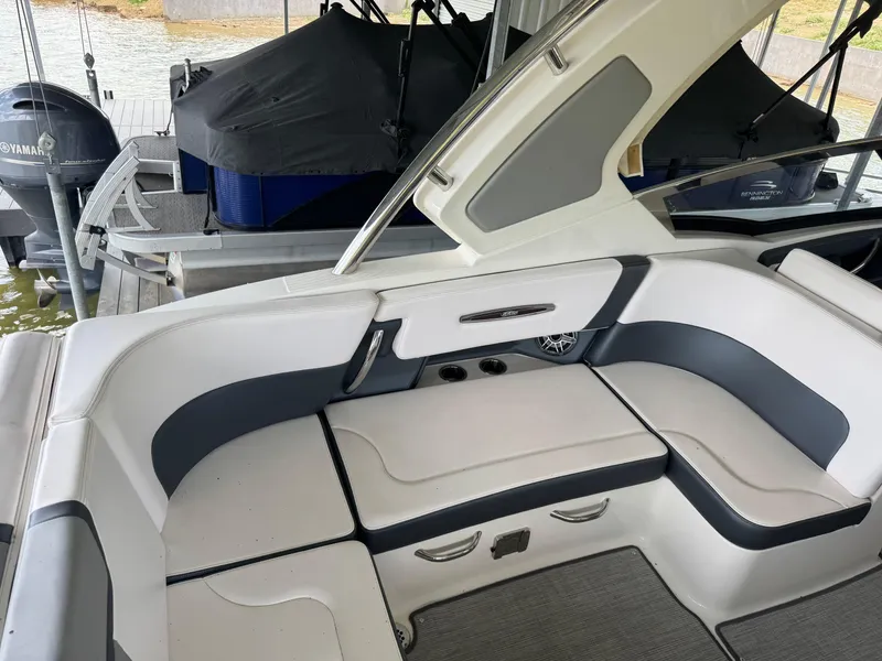 Slide: The Image of 2020 Chaparral 317 SSX boat interior with white and gray seating, docked by the water. - 17