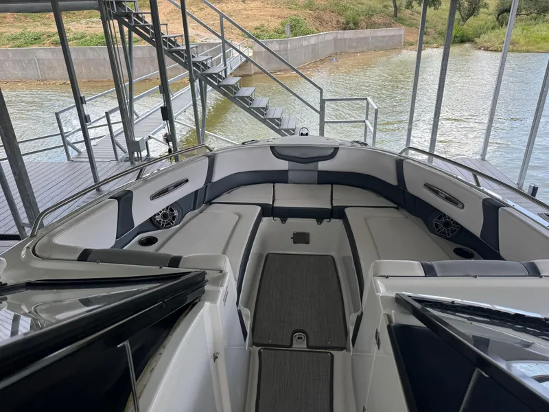 Slide: The Image of 2020 Chaparral 317 SSX boat interior with seating, docked by a lake. - 24