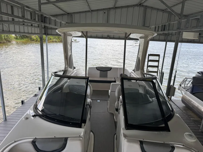 Slide: The Image of 2020 Chaparral 317 SSX boat docked under a metal canopy by the water. - 28