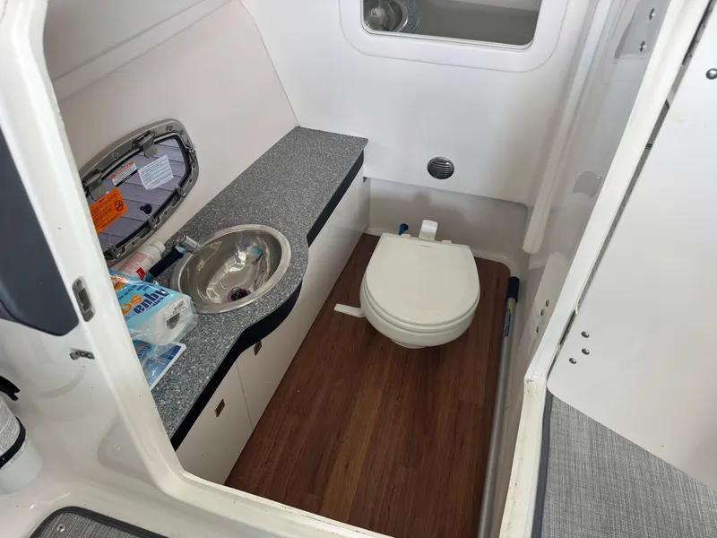Slide: The Image of 2020 Chaparral 317 SSX boat bathroom with sink, toilet, and wood flooring. - 29