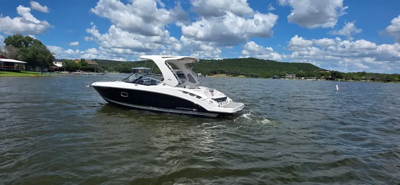 Slide: The Image of 2020 Chaparral 317 SSX boat cruising on a scenic lake under a partly cloudy sky. - 3