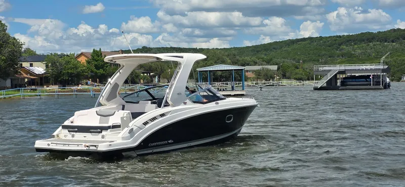 Slide: The Image of 2020 Chaparral 317 SSX boat cruising on a scenic lake under a partly cloudy sky. - 7