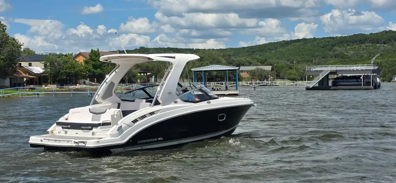 Slide: The Image of 2020 Chaparral 317 SSX boat cruising on a scenic lake under a partly cloudy sky. - 8