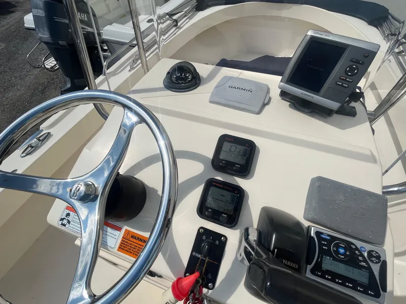 Slide: The Image of 2011 Parker 21SE Center Console boat dashboard with Garmin navigation system and Yamaha controls. - 21