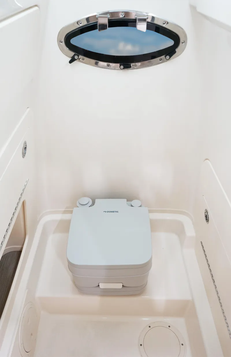 Slide: The Image of 2025 Grady-White Fisherman 236 boat interior with portable toilet and porthole window. - 14