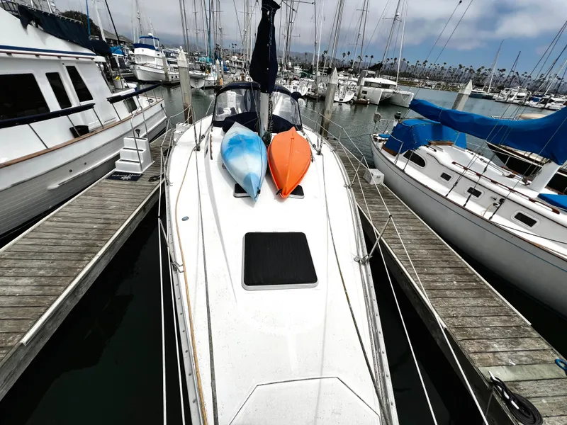 Slide: The Image of Sailboat docked with kayaks on deck, Hunter 40 model, 1988, in a marina setting. - 11