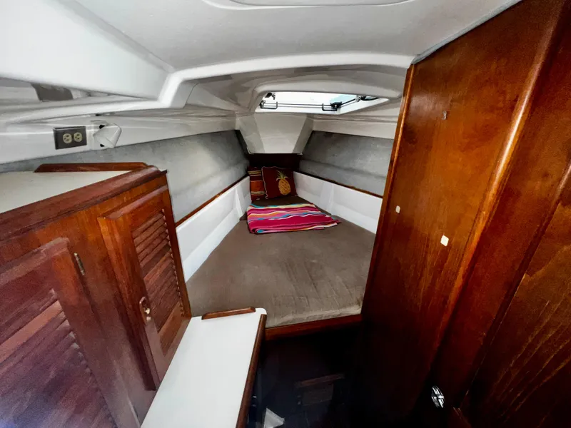 Slide: The Image of Interior cabin of 1988 Hunter 40 sailboat with wooden furnishings and cozy sleeping area. - 21
