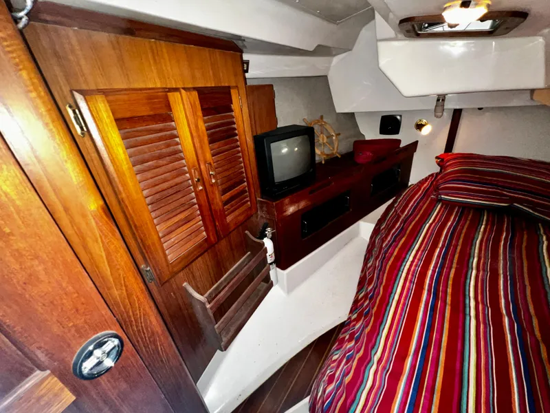 Slide: The Image of Cozy cabin interior of 1988 Hunter 40 sailboat with striped bedding and wooden cabinetry. - 29