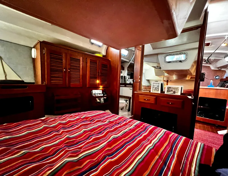 Slide: The Image of Interior of a 1988 Hunter 40 sailboat with striped bedding and wooden cabinetry. - 30