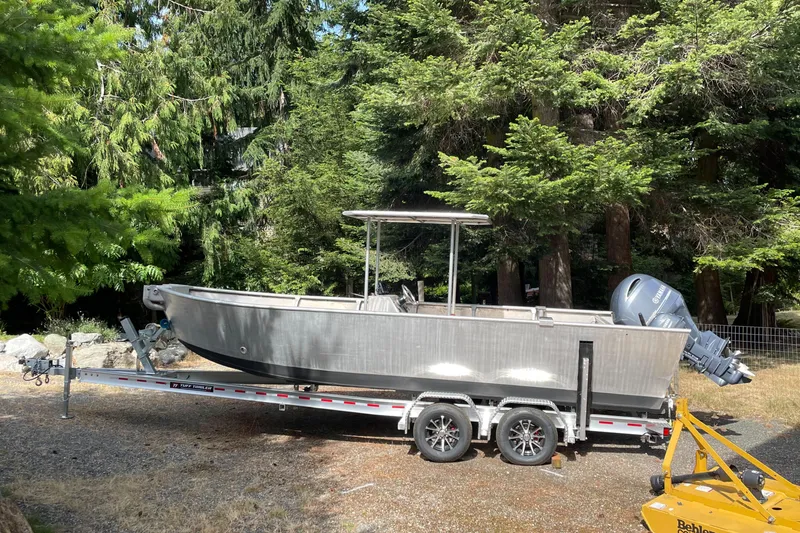 Slide: The Image of 2006 Pacific Boats 22 on trailer, surrounded by lush green trees. - 2
