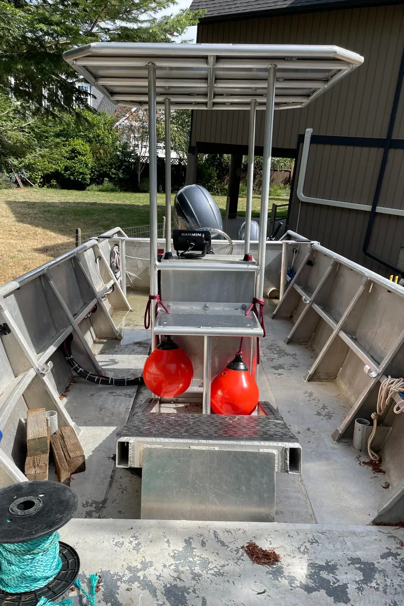 Slide: The Image of 2006 Pacific Boats 22 with open deck, red buoys, and outboard motor in a yard setting. - 5