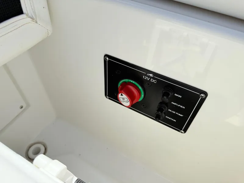 Slide: The Image of 2018 Monterey 218 Super Sport boat control panel with 12V DC switches and red knob. - 30