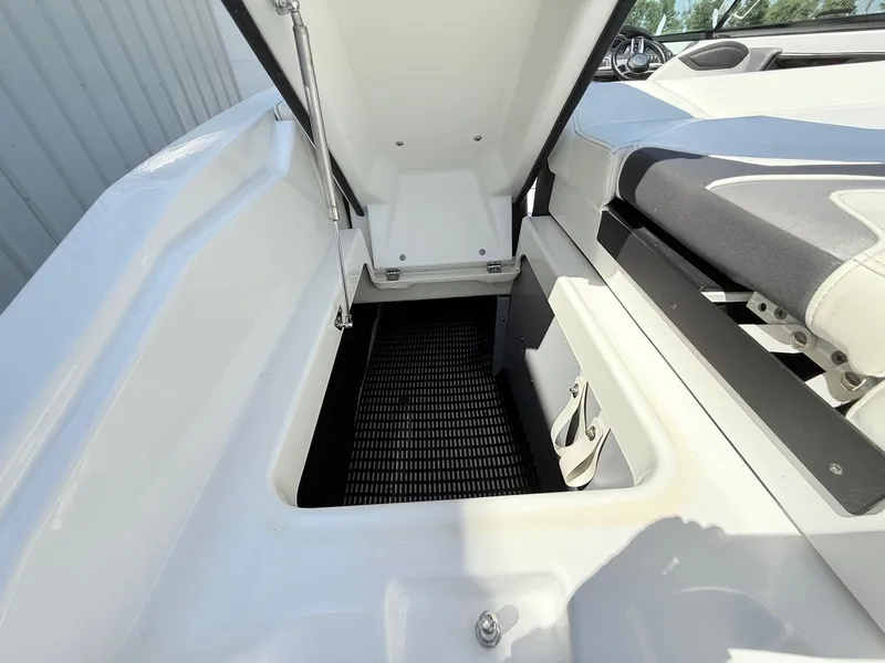 Slide: The Image of 2018 Monterey 218 Super Sport boat storage compartment with open hatch and seating area. - 34