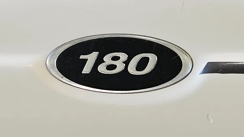 Slide: The Image of Close-up of 2005 Sea Ray 180 Sport emblem on white surface. - 19